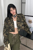 Person wearing a camouflage jacket and green pants in an indoor setting.