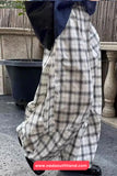 Person wearing a long plaid skirt with a blurred background