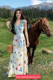 Woman in a floral dress standing next to a horse in a mountainous landscape