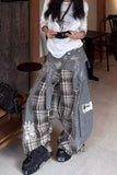 Person wearing a unique outfit with plaid pants and black shoes in an indoor setting.