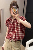 Person wearing a red and white checkered shirt taking a mirror selfie.