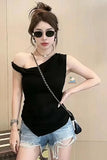 Woman wearing a black off-shoulder top and denim shorts with sunglasses indoors.
