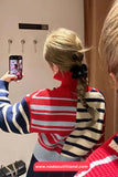 Person wearing a red, white, and blue striped sweater taking a mirror selfie.