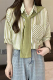Person wearing a green and white striped shirt with a green scarf, standing indoors.