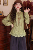 Woman wearing a green knitted blouse with lace details in a vintage room.
