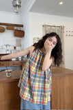 Woman wearing a colorful plaid dress in a kitchen setting