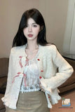 Woman wearing a white cardigan over a floral top in an indoor setting