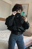 Person wearing a black leather jacket and blue jeans taking a mirror selfie.