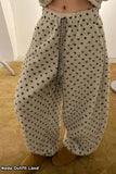 Beige pants with black heart patterns worn by a person indoors.