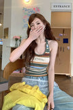 Woman sitting on a chair with a striped tank top and jeans in an indoor setting.