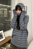 Person wearing a striped hoodie in an indoor setting