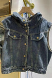 Denim vest on a hanger against a neutral background