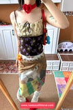 Person wearing a colorful outfit with a floral top and patterned skirt in a room.