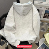 Gray hoodie on a chair with a magazine rack in the background