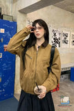 Person wearing a brown jacket in an urban setting with posters on the wall.