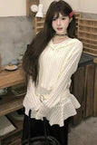 Woman wearing a white ribbed sweater in an indoor setting