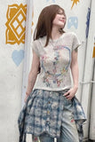 Person wearing a floral top and checkered skirt against a colorful wall.