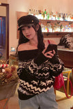 Woman in a bar setting wearing a black and white patterned sweater, holding a phone.