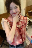 Woman wearing a red and white checkered shirt with ruffled sleeves in an indoor setting.