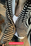 Person wearing a black and white striped sweater with a blurred background