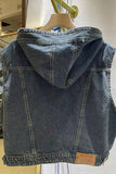 Blue denim vest with hood on a hanger against a white background