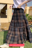 Person wearing a plaid skirt outdoors with a blurred background