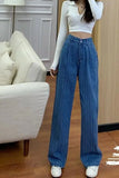 Person wearing blue ribbed pants and a white top in a living room setting.
