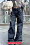 Person wearing dark blue flared jeans with a blurred background