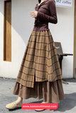 Person wearing a brown plaid skirt and top in an outdoor setting.