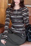 Person wearing a striped long-sleeve shirt sitting on a couch.
