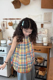 Person wearing a plaid apron in a kitchen setting