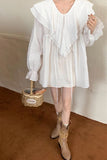 Person wearing a white ruffled blouse and beige boots, holding a woven basket.