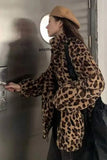 Person wearing a leopard print coat and tan hat interacting with a metallic door.