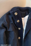 Navy blue coat with button details on a beige background