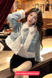 Woman wearing a denim jacket with white fur lining in an indoor setting.
