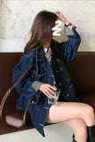 Woman wearing a blue denim jacket sitting on a bench.