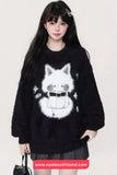 Person wearing a black sweater with a white cat design on a plain background