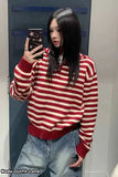 Person wearing a red and white striped sweater taking a mirror selfie.