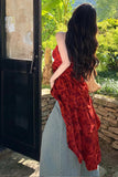 Woman in a red dress standing by a door with a garden view