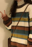 Person wearing a striped sweater with a peace sign gesture