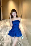 Woman in a blue strapless dress standing in a hallway.