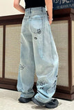 Light blue jeans with decorative elements worn by a person indoors.