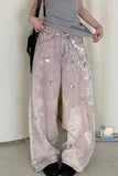 Person wearing floral embroidered wide-leg pants with a plain background