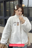 Person wearing a white jacket with patches in an outdoor setting
