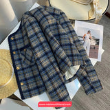 Plaid jacket on a table with a magazine and hat in the background