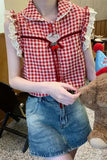 Person wearing a red and white checkered shirt with ruffled details, holding a teddy bear.