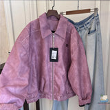 Purple jacket with a tag on a hanger next to light blue jeans against a white wall.