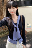 Woman wearing a blue checkered scarf outdoors with a visible brand logo.