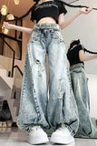 Person wearing embellished light blue jeans and a black crop top in an indoor setting.