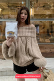 Woman wearing a beige off-shoulder sweater holding a product package in an indoor setting.